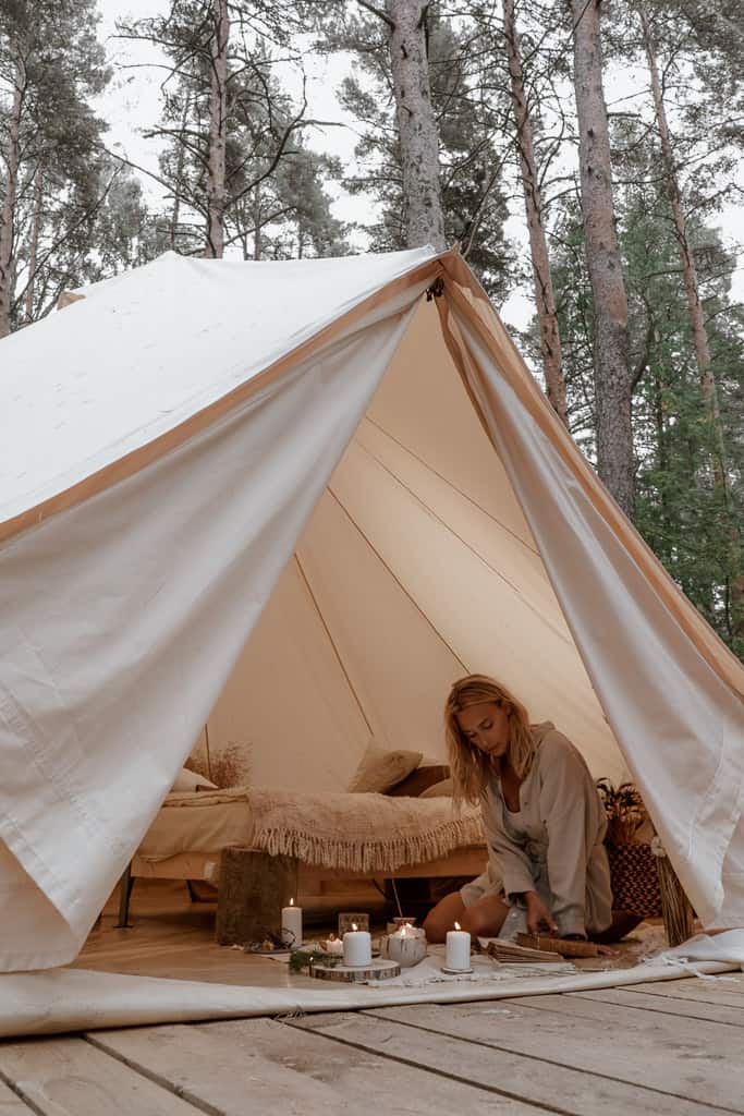 woman enjoys a book outside luxury tent.